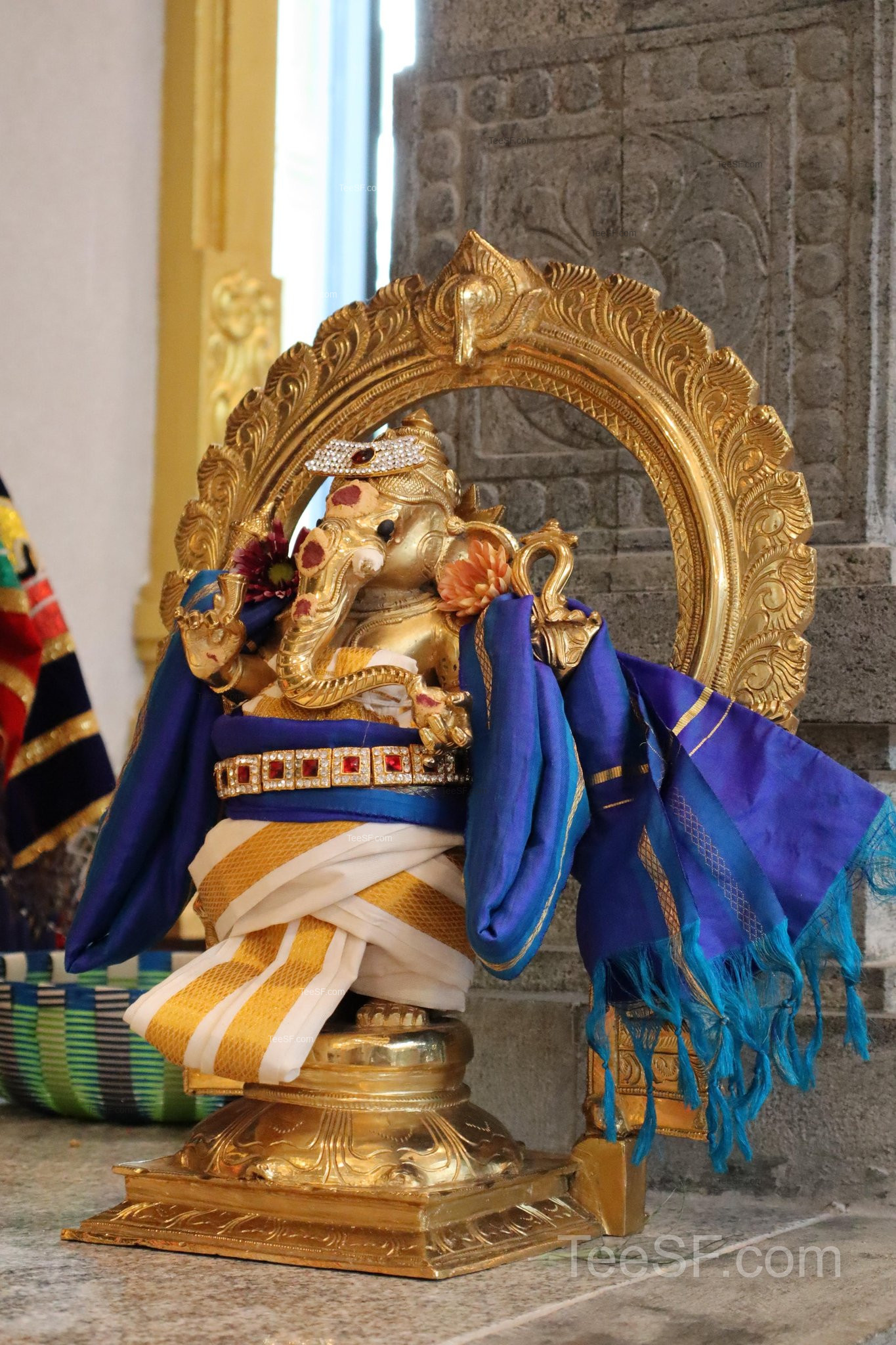 A seated temple figure with rich blue and gold details.